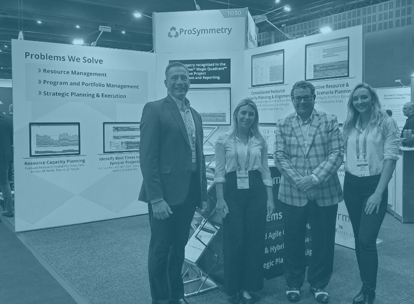 ProSymmetry team posing at display booth for an event.